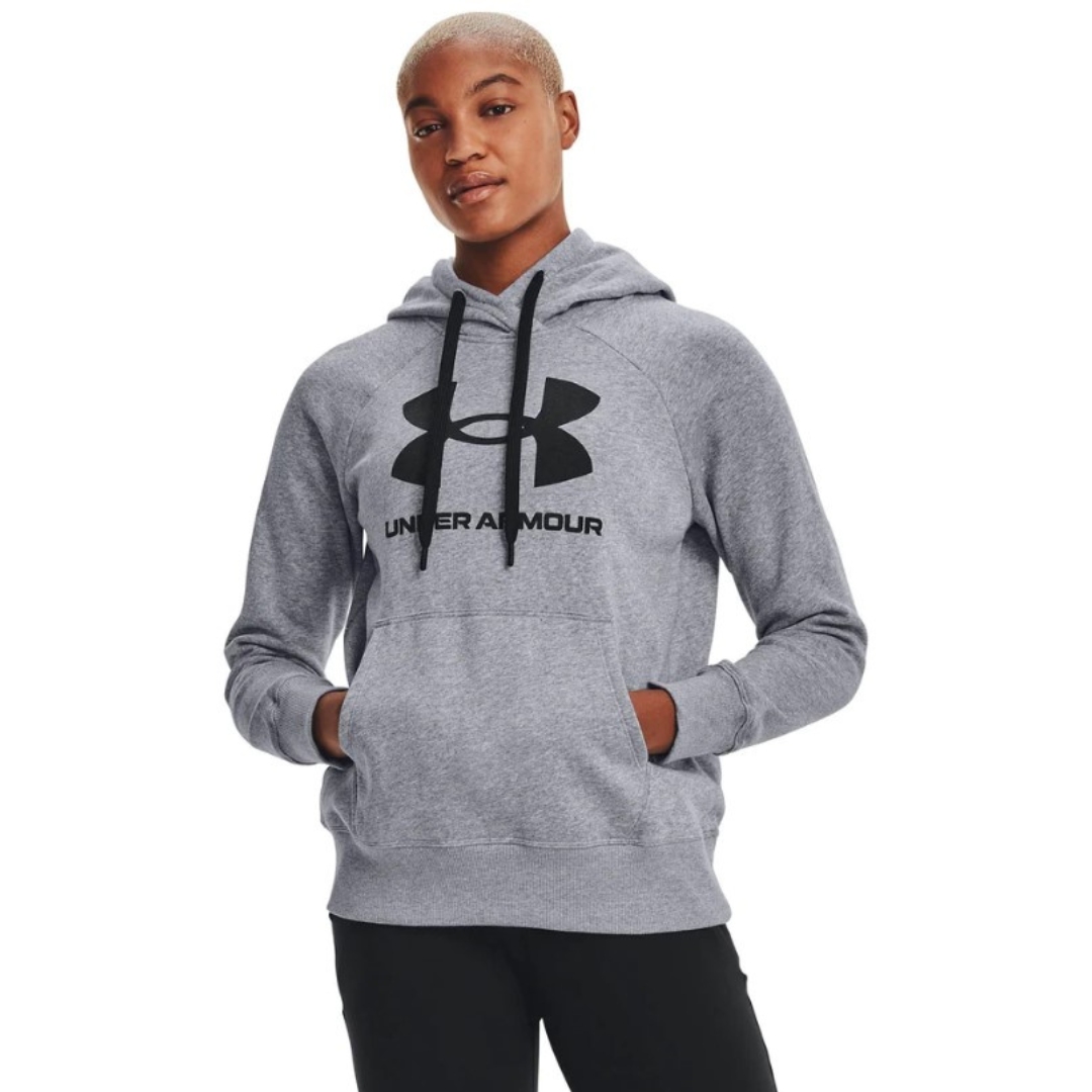 CHANDAIL À CAPUCHON RIVAL FLEECE LOGO POUR FEMME couleur 035-STEEL MEDIUM HEATHER/BLACK porté par une femme chandail à manches longues gris chiné avec imprimé noir, cordons de serrage de la capuche noir et la femme a les mains dans la poche kangourou avant