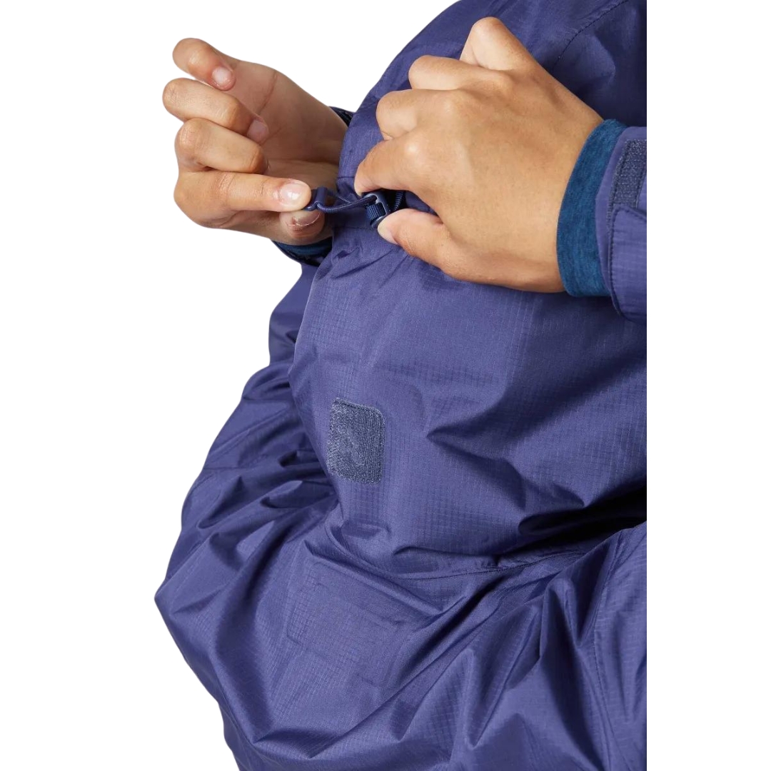 MANTEAU IMPERMÉABLE RAB DOWNPUR PLUS 2.0 POUR FEMME vu couleur PATRIOT BLUE vu du manteau bleu foncé porté par une femme vue ajustant la grandeur du capuchon par l'arrière