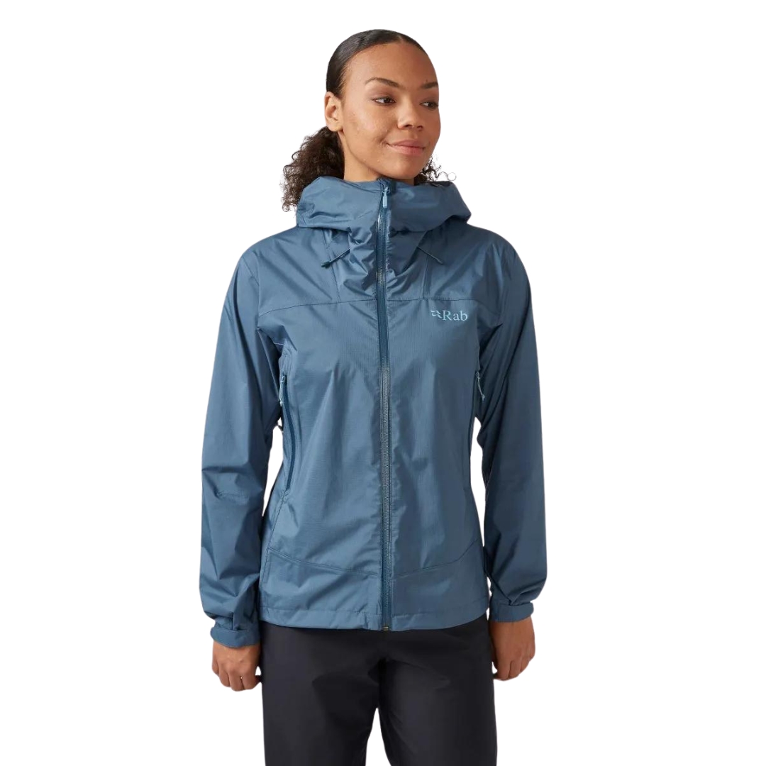 MANTEAU IMPERMÉABLE RAB DOWNPUR PLUS 2.0 POUR FEMME vu couleur orion blue vu du manteau bleu acier porté par une femme vue de la tête aux cuisses de profil avant droit