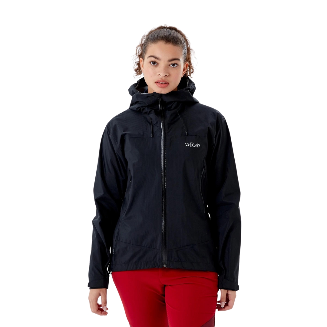 MANTEAU IMPERMÉABLE RAB DOWNPUR PLUS 2.0 POUR FEMME vu couleur black vu du manteau noir porté par une femme vue de la tête aux cuisses de profil avant droit