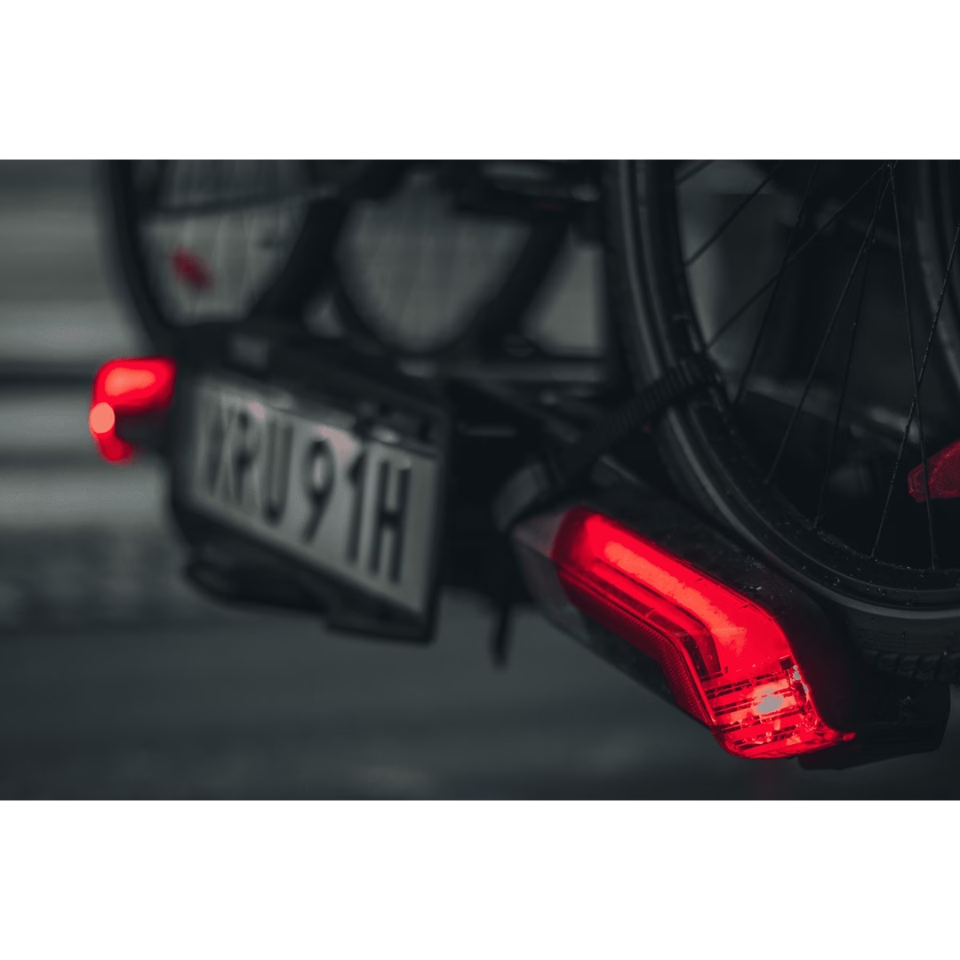 PORTE VÉLO THULE EPOS 2 AVEC LUMIÈRE couleur black/aluminium vu du porte vélo noir surun véhicules, les lumières du porte vélo allumées