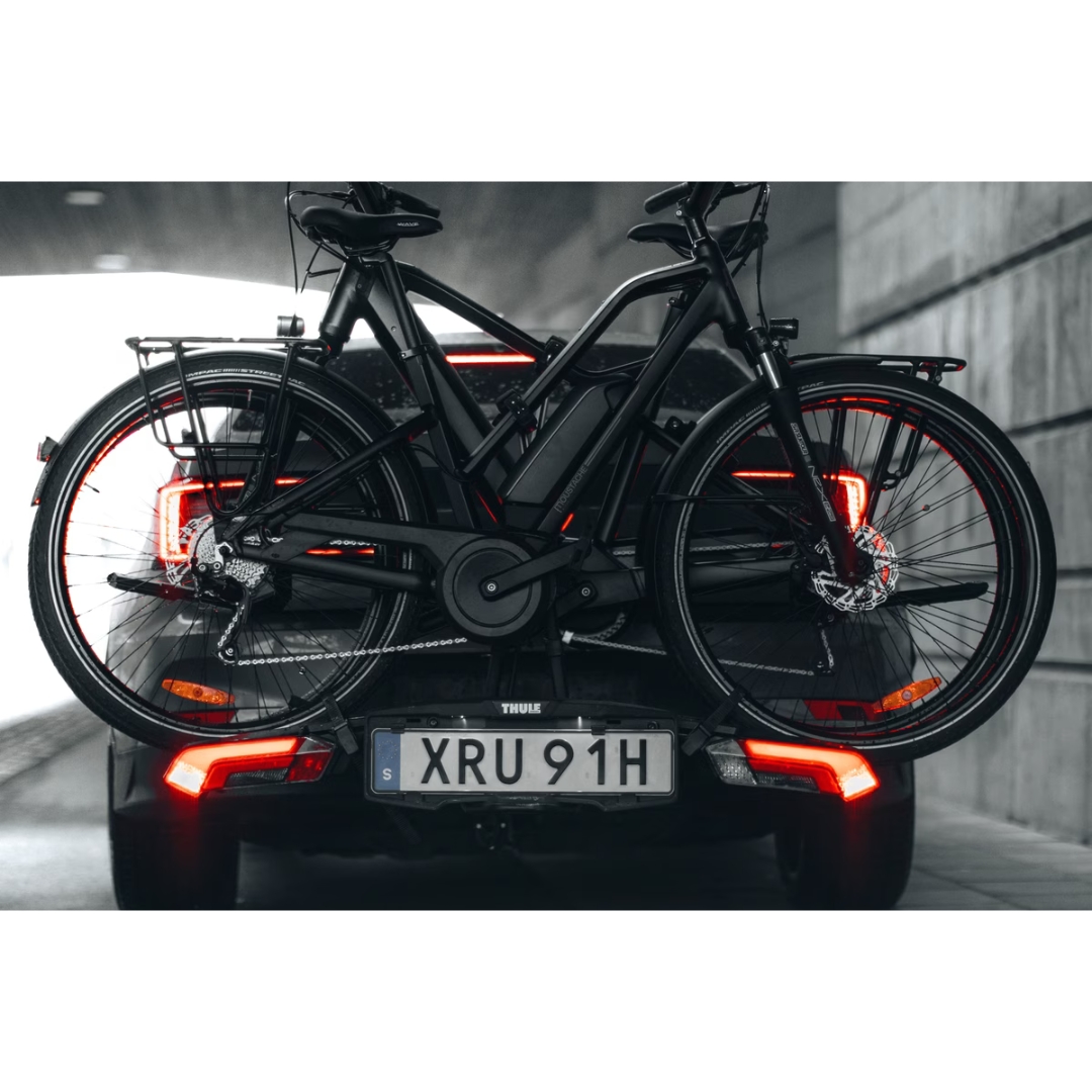 PORTE VÉLO THULE EPOS 2 AVEC LUMIÈRE couleur black/aluminium vu du porte vélo noir surun véhicules, les lumières du porte vélo allumées