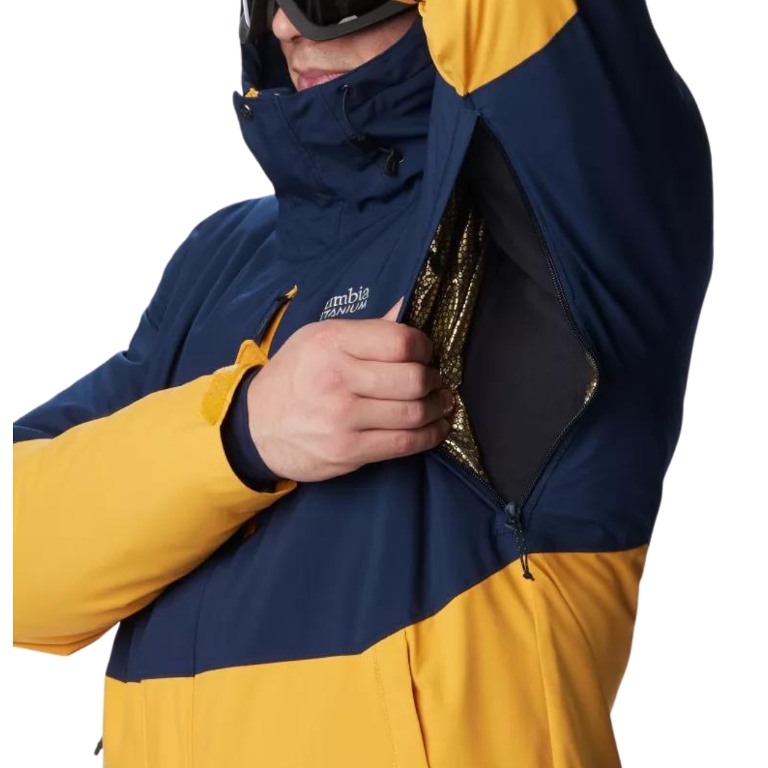MANTEAU DE SKI ALPIN COLUMBIA WINTER DISTRICT II POUR HOMME couleur 756-RAW HONEY/COLLEGIATE navy vu du manteau bleu marin foncé et jaune ocre porté par un homme montrant les ouvertures sous les aisselles pour l'aération