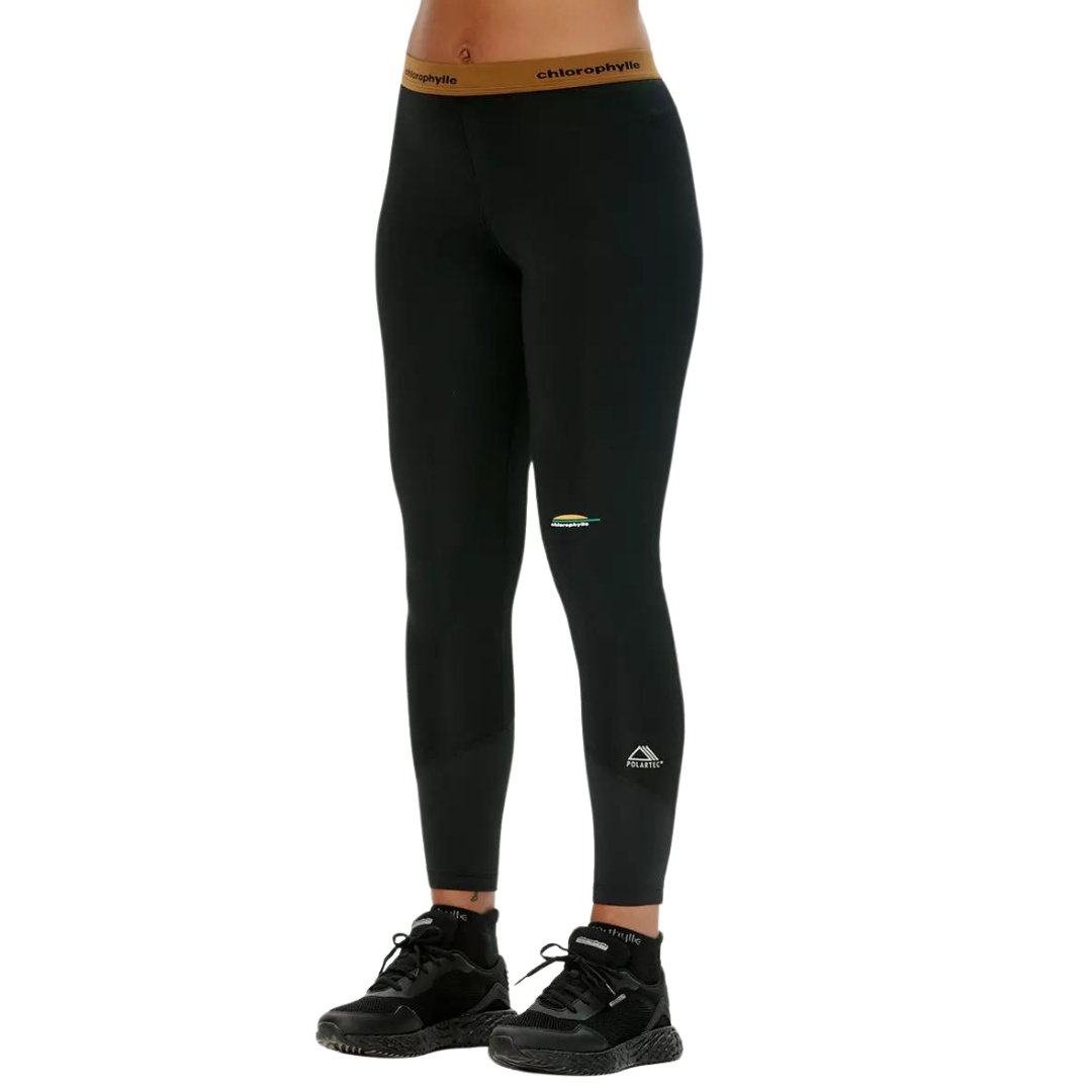 LEGGING COUCHE DE BASE CHLOROPHYLLE CHL ULTRA POUR FEMME couleur noir pur vu du legging noir avec band élastique a la taile brune porté par une femme vu e de la taille aux pieds de profil avant gauche