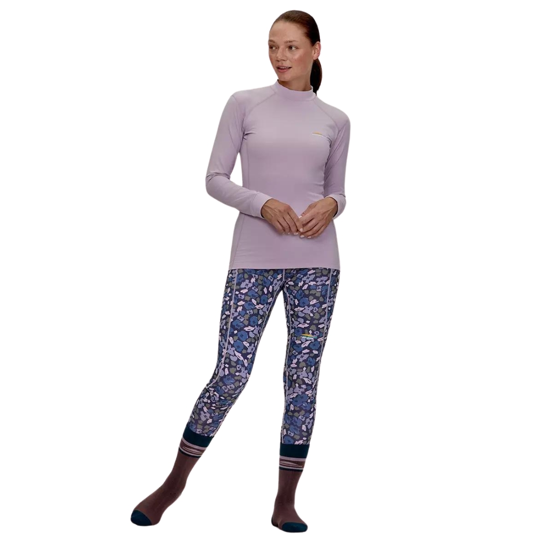 LEGGING COUCHE DE BASE CHLOROPHYLLE CHL2 POUR FEMME couleur FLEUR BLEU ODYSSÉE vu du legging bleu marin avec motif fleuraux abstrait dans les tons de bleu royal, lilas et vert olive porté par une femme vue de la tête aux pieds de face