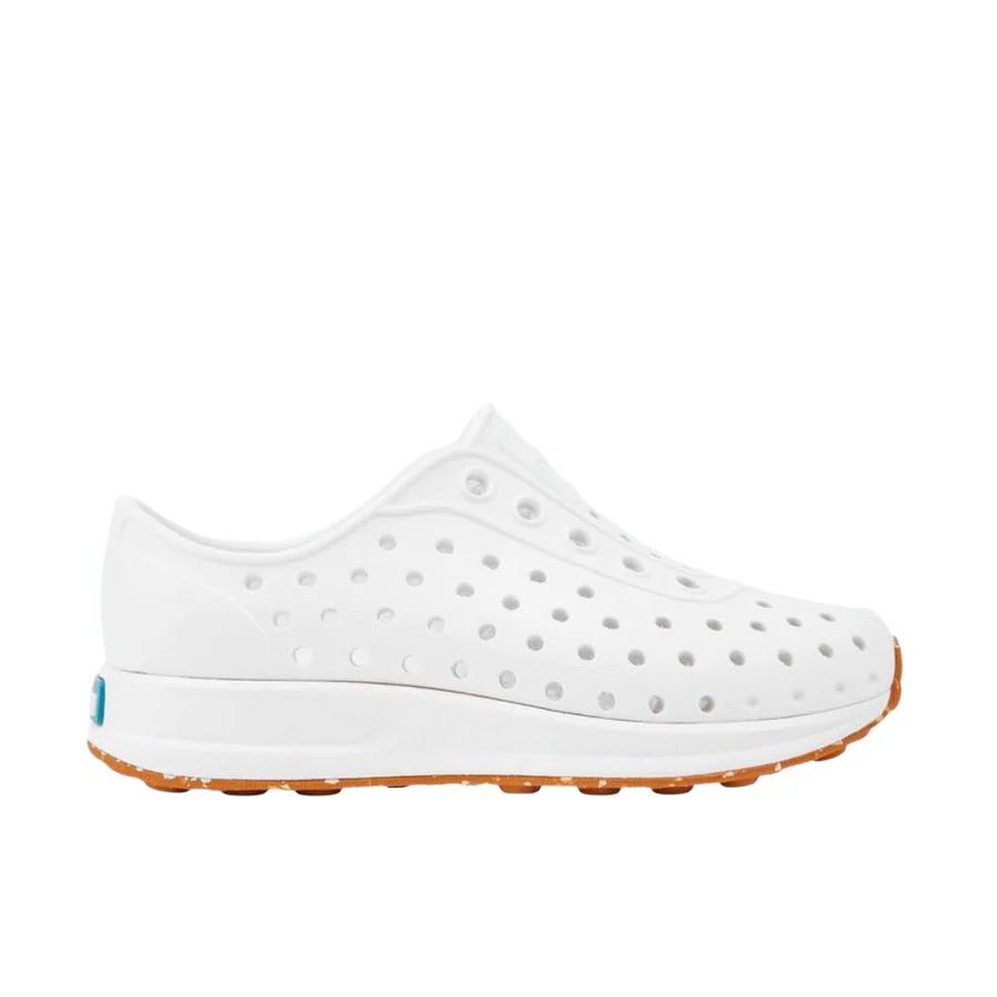 La ROBBIE SUGARLITE JUNIOR est une chaussure à enfiler blanche avec un design perforé et une semelle en caoutchouc tan, présentée de profil sur un fond blanc uni.