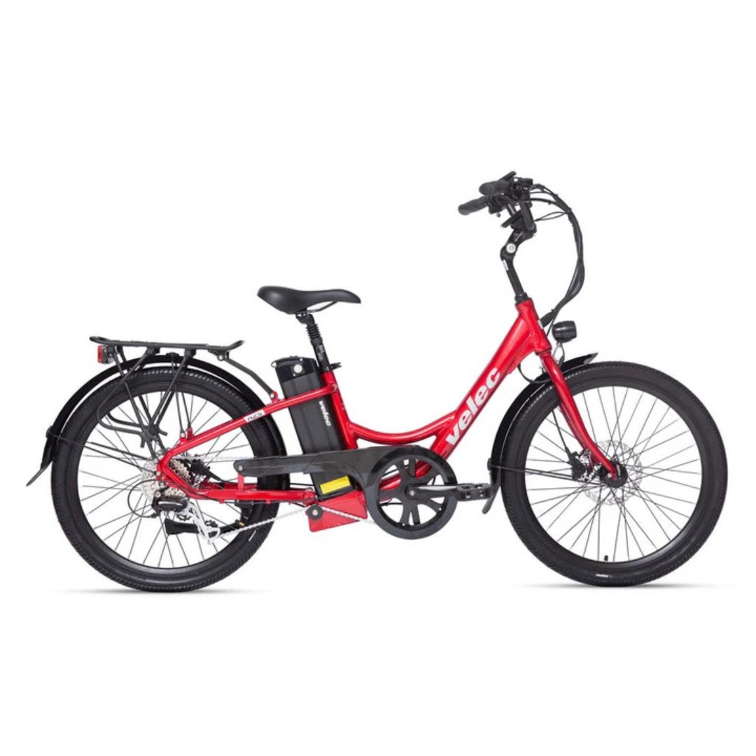 Un vélo électrique rouge avec un cadre traversant, une selle noire, un porte-bagages arrière et une batterie montée derrière la tige de selle, présenté de côté sur fond blanc.