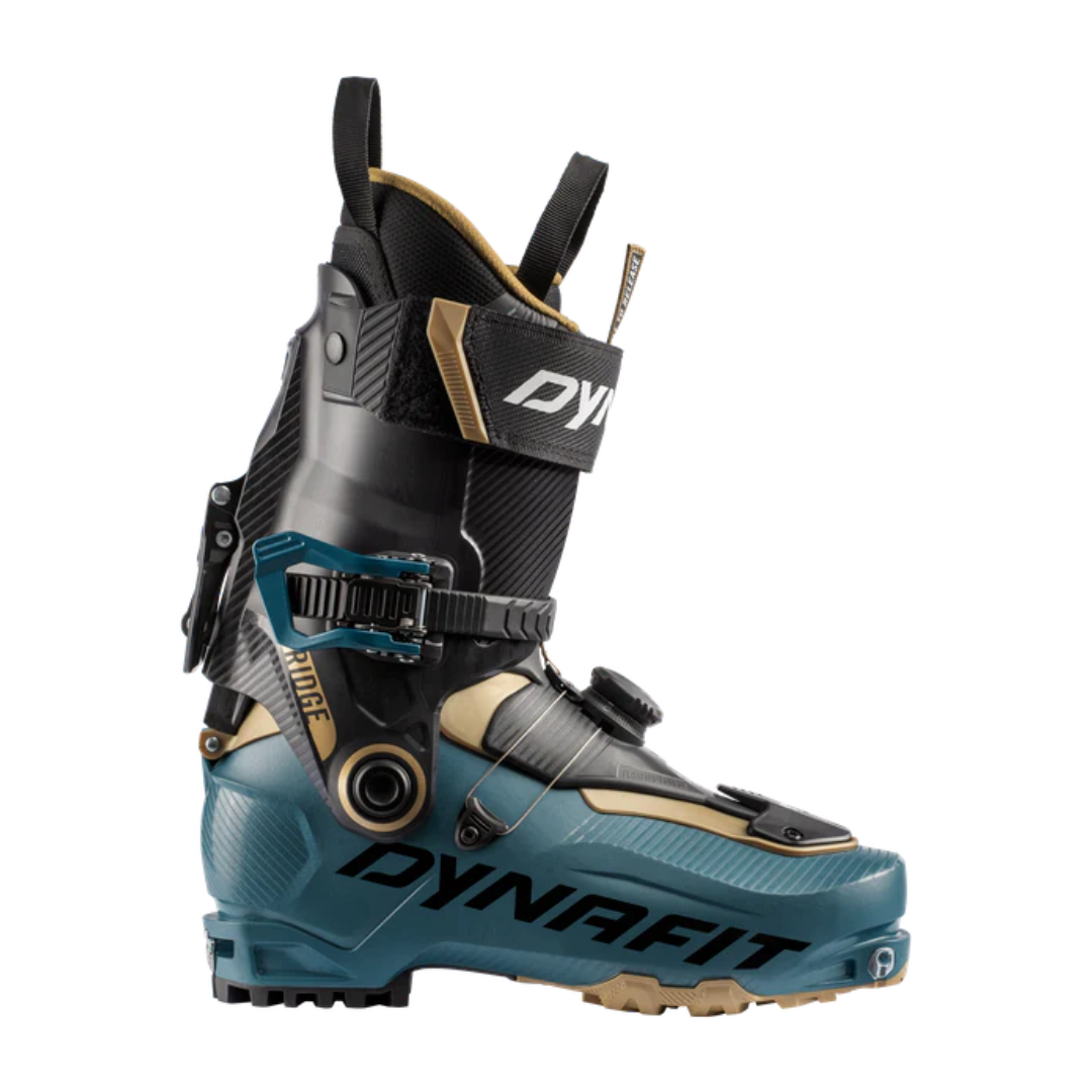 Vue latérale d'une chaussure de ski RIDGE en bleu sarcelle et noir, dotée d'une conception durable, de boucles réglables et d'une boucle en tissu pour une manipulation facile. Le nom de la marque est affiché bien en évidence sur le côté.