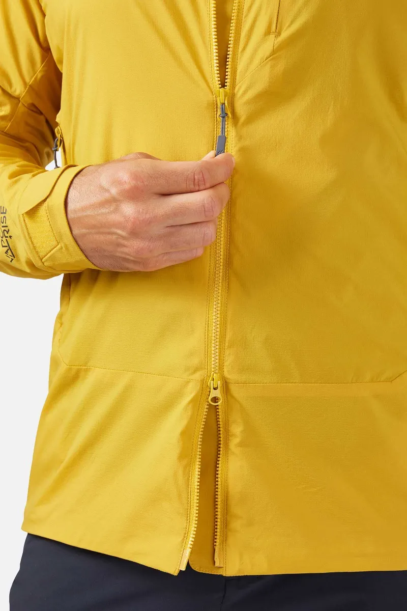 Une personne porte une veste jaune vif et la ferme. La veste comporte deux fermetures éclair en haut et en bas. La main gauche de la personne est visible, tenant la fermeture éclair supérieure, et elle porte un pantalon foncé.